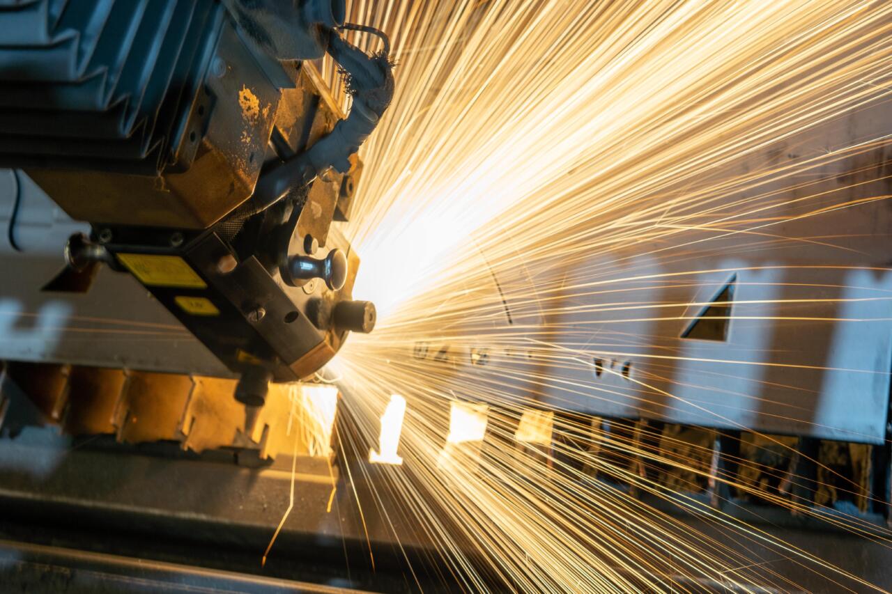Close-up van een machine die heldere vonken afgeeft tijdens het gebruik in een industriële omgeving. Close-up of a machine emitting bright sparks during operation in an industrial setting.