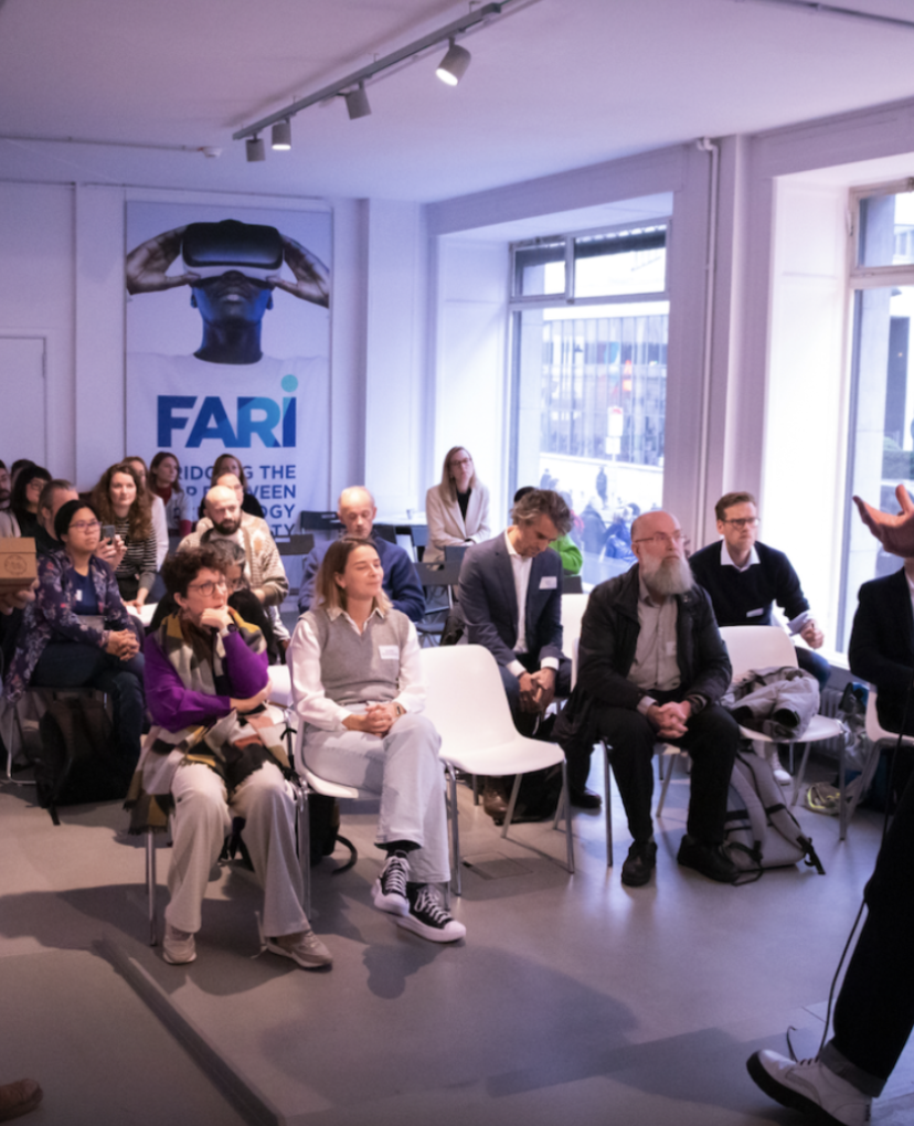 People seated in a conference room listening to a presentation.