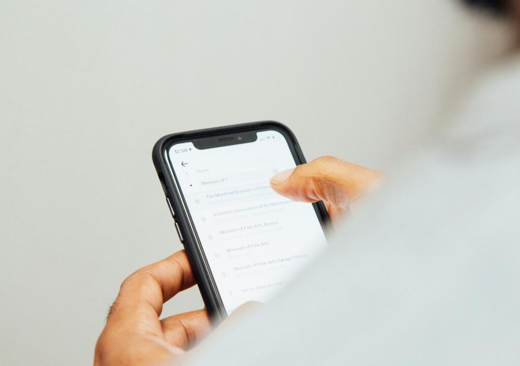 person photographed from the back. The photo shows a person scrolling on the phone.