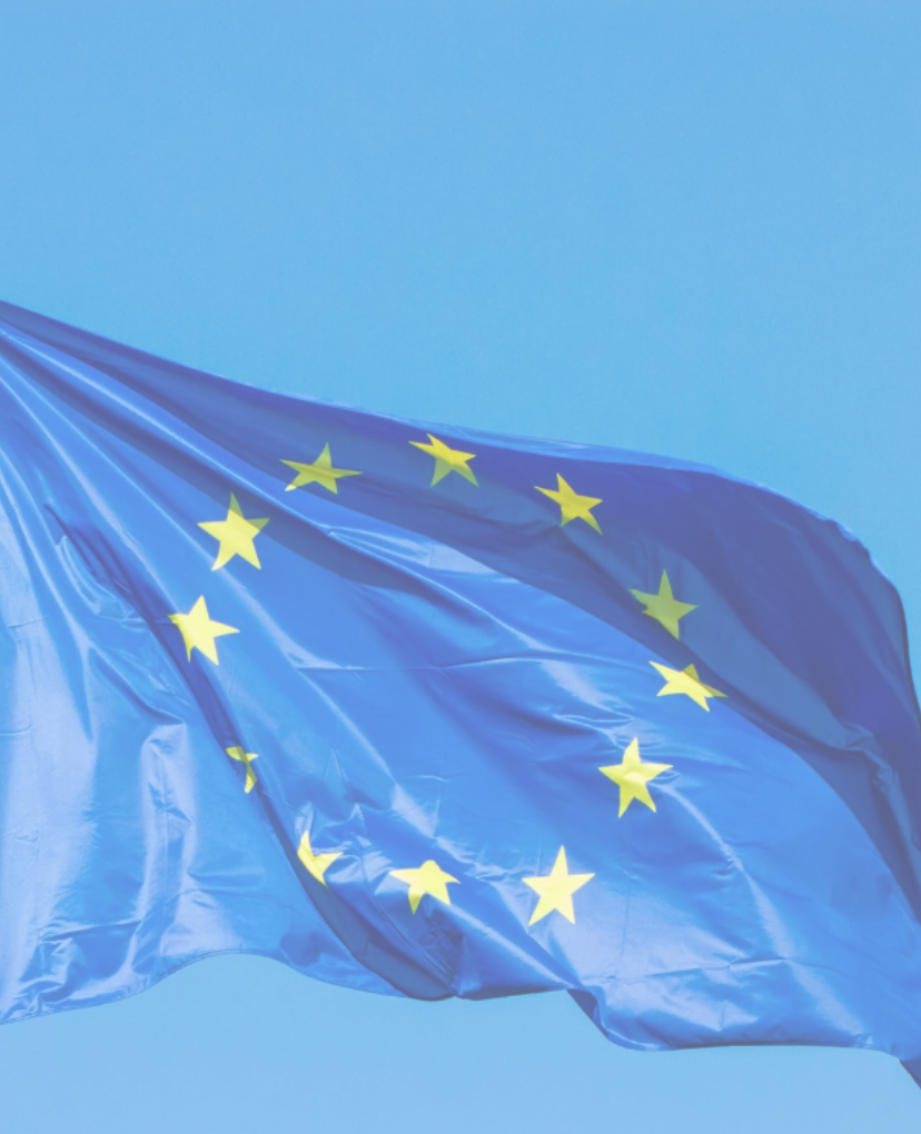 Vlag en wimpel van de Europese Unie (donkerblauw met gele sterren in een cirkel) tegen een blauwe lucht. 
Flag and pole of the EU (blue and yellow stars in a circle against the background of the blue sky.