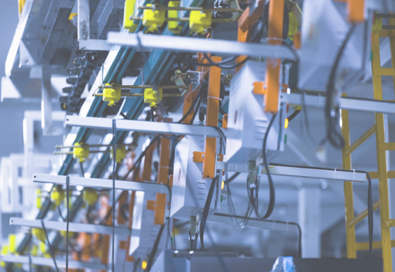 Close-up view of a fully automated line for the dynamic testing of cooling performance in a refrigerator manufacturing plant.
